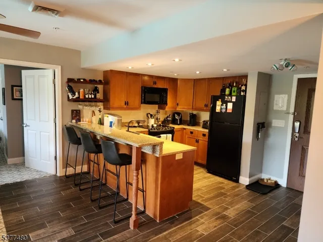 a kitchen with stainless steel appliances granite countertop a refrigerator and a stove top oven