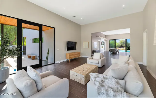 a dining room with wooden floor a glass table and a large window