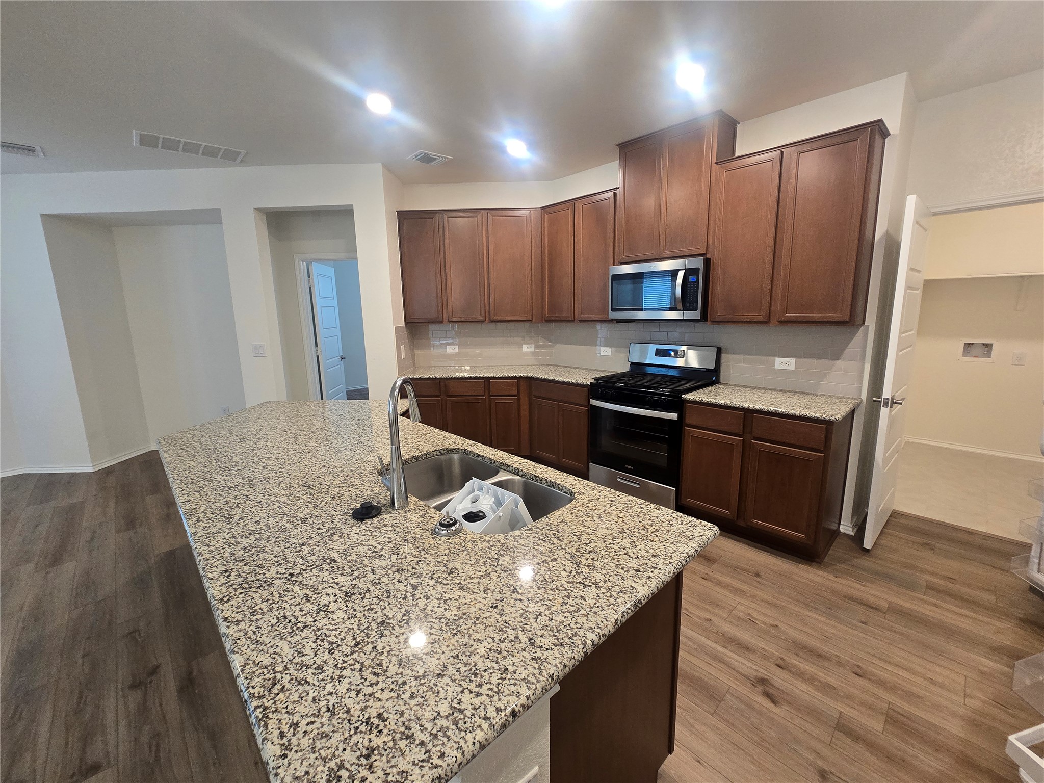 210 Summit Drive Lockhart, TX 78644 - Photo 5 of 21 a kitchen with kitchen island granite countertop a sink a counter top space appliances and cabinets