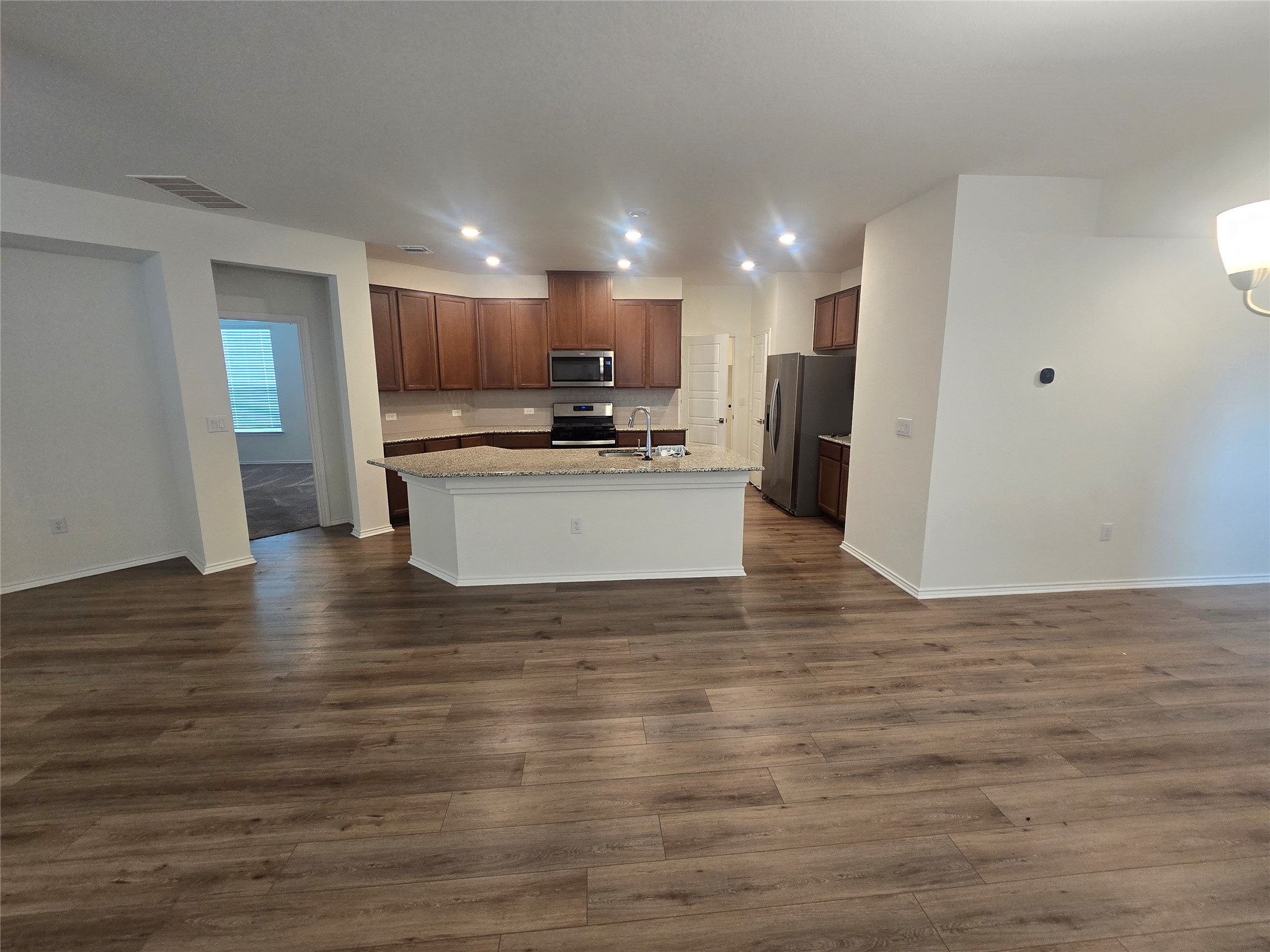 210 Summit Drive Lockhart, TX 78644 - Photo 6 of 21 a view of kitchen with kitchen island a sink wooden floor and a refrigerator