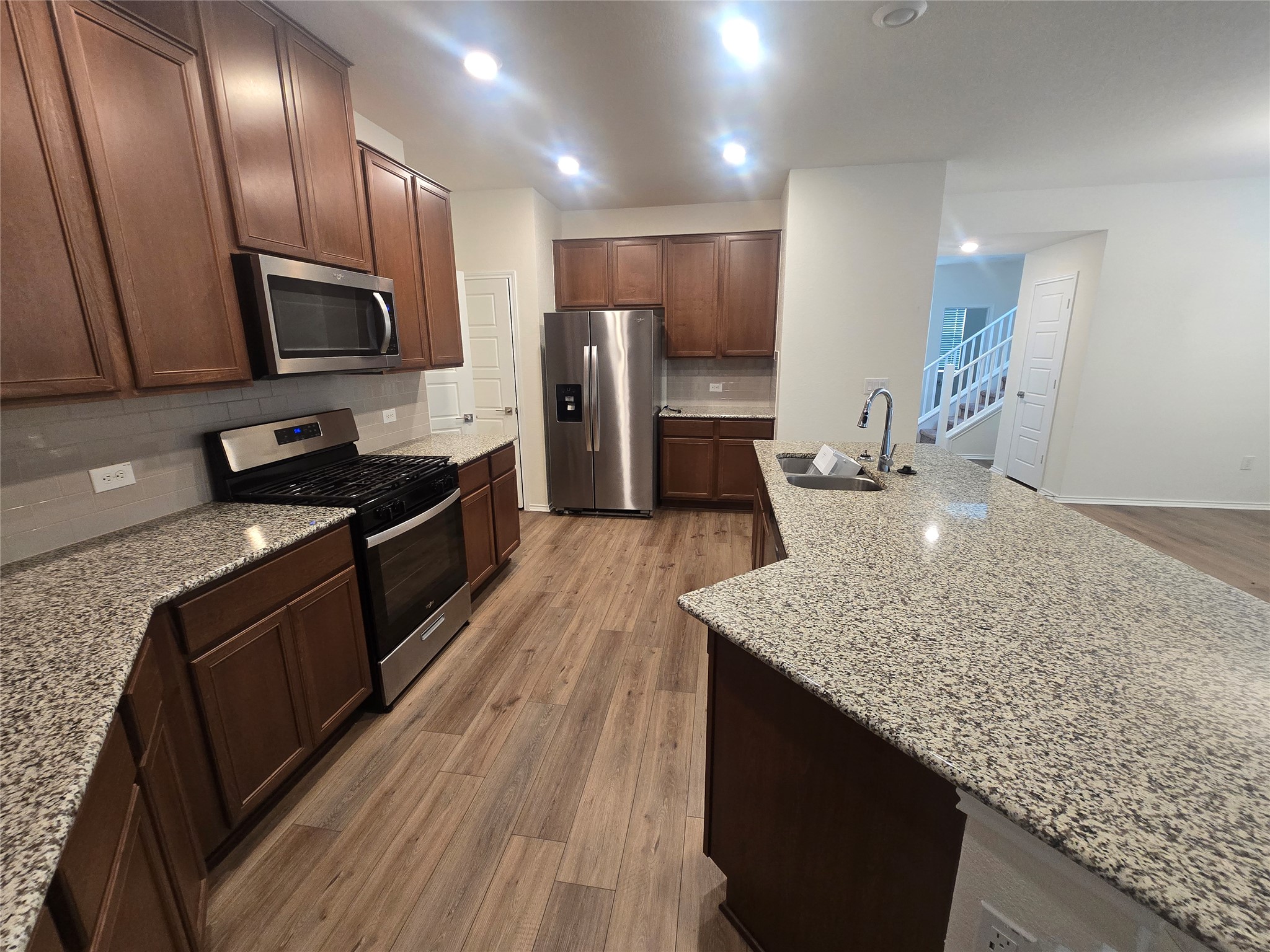 210 Summit Drive Lockhart, TX 78644 - Photo 7 of 21 a kitchen with stainless steel appliances granite countertop a sink stove and refrigerator