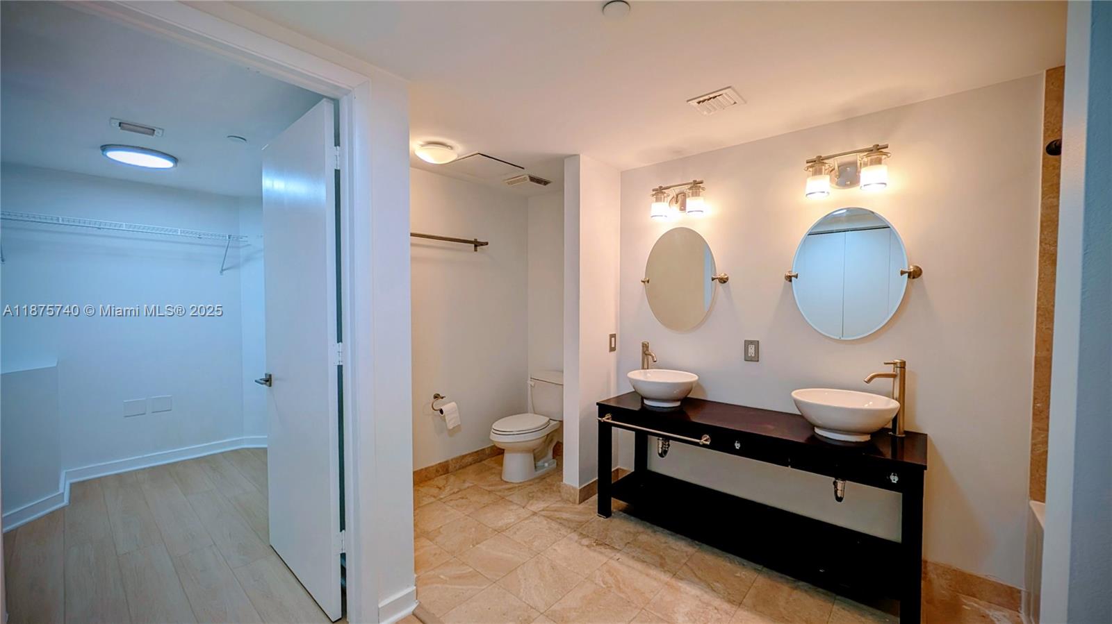 350 South Miami Avenue, Unit 1901 Miami, FL 33130 - Photo 27 of 81 a room with a mirror light fixtures and a walk in closet