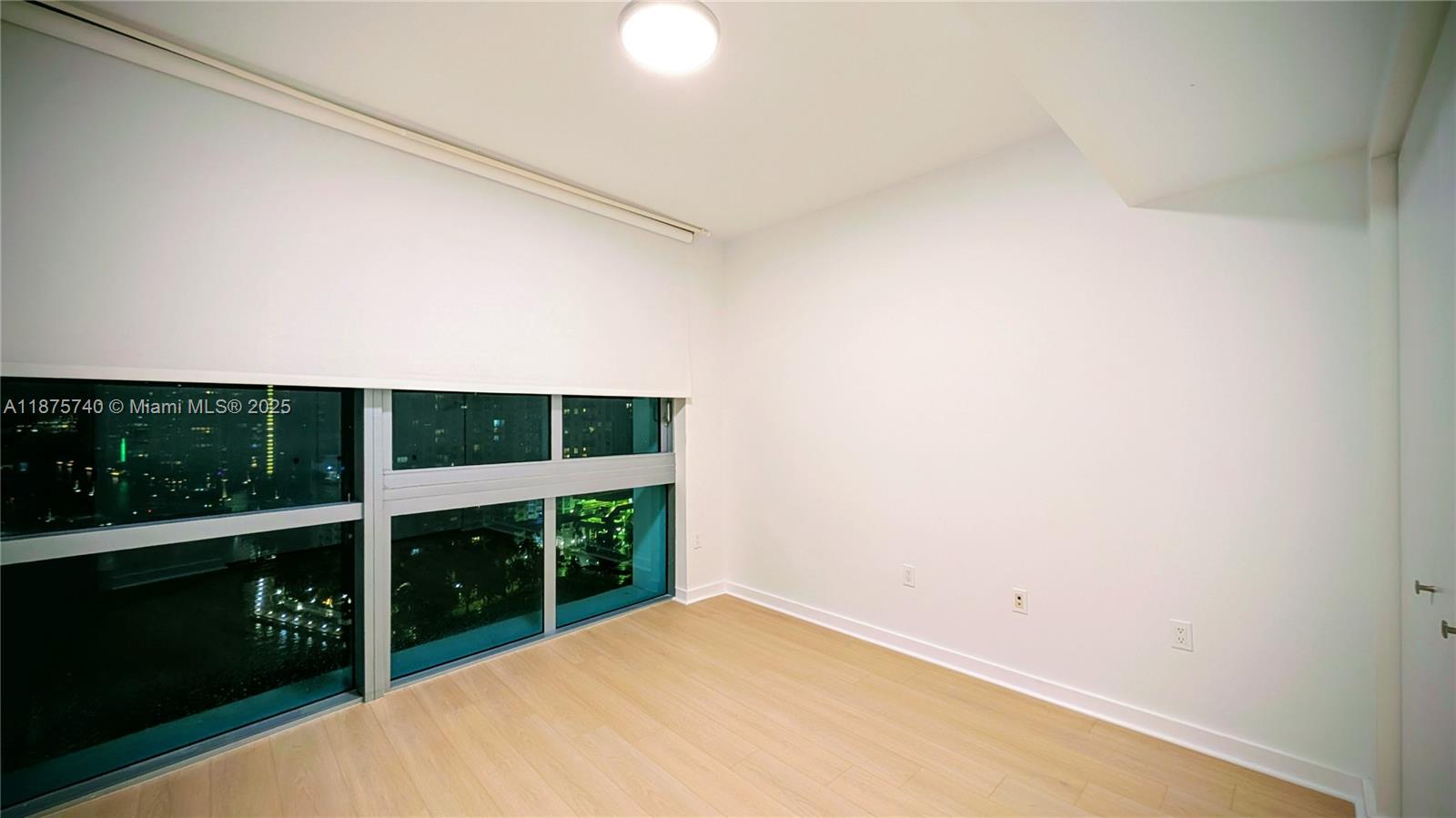 350 South Miami Avenue, Unit 1901 Miami, FL 33130 - Photo 33 of 81 a view of an empty room with wooden floor and a window