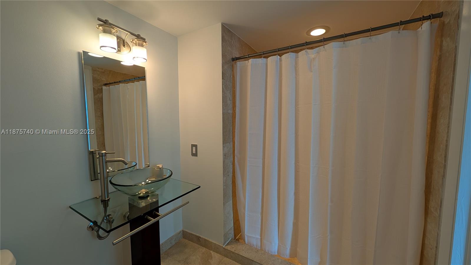 350 South Miami Avenue, Unit 1901 Miami, FL 33130 - Photo 48 of 81 a bathroom with a mirror and a shower curtain