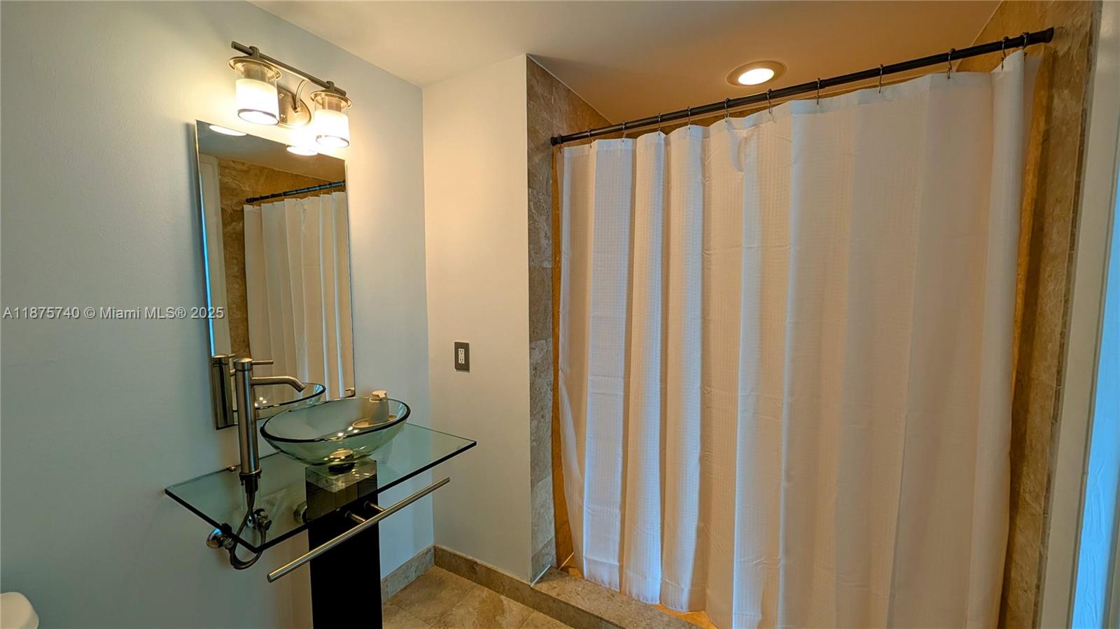 350 South Miami Avenue, Unit 1901 Miami, FL 33130 - Photo 49 of 81 a bathroom with a mirror and a shower curtain