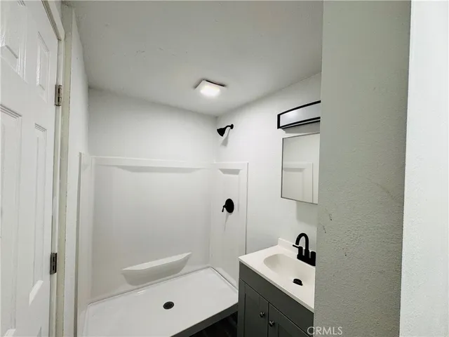 a bathroom with a bathtub shower sink vanity and toilet