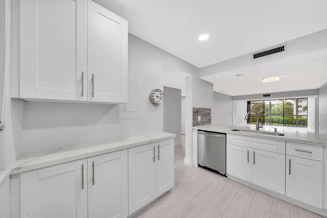 a kitchen with white cabinets appliances and sink