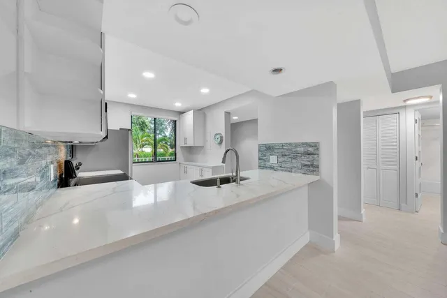 a large kitchen with kitchen island a sink stainless steel appliances and cabinets