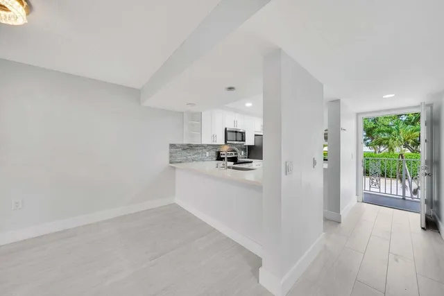 a view of a kitchen with refrigerator and windows