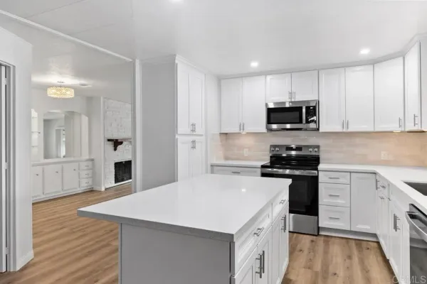 a kitchen with stainless steel appliances a sink stove refrigerator and cabinets