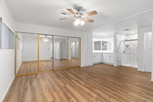 a spacious bedroom with a bed and a chandelier