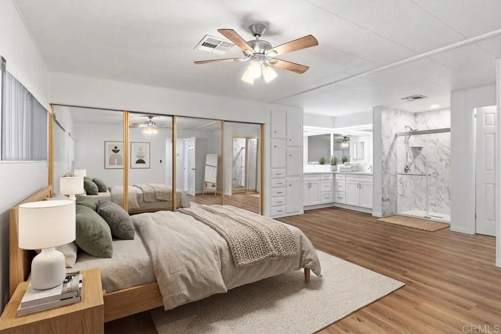 7467 Mission Gorge Road, Unit SPC 10 Santee, CA 92071 - Photo 23 of 44 a spacious bedroom with a bed and a chandelier