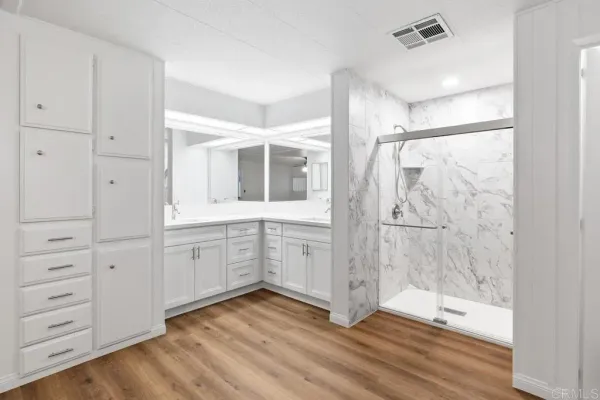 a bathroom with a double vanity sink a mirror and a shower