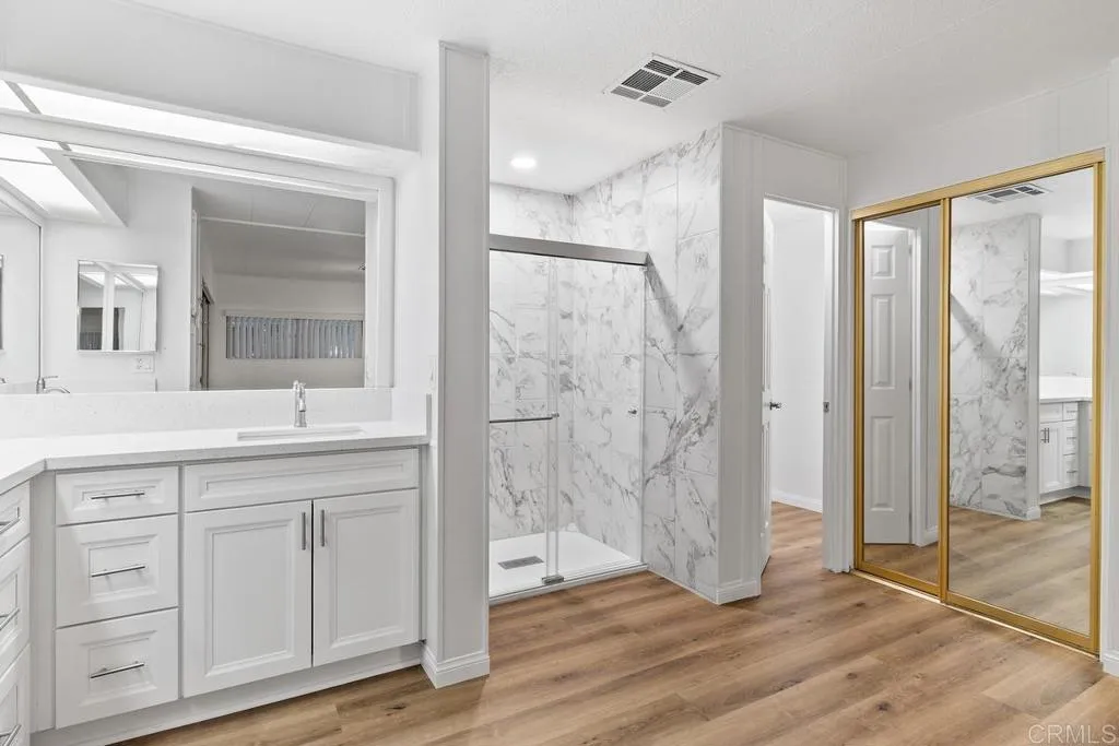 7467 Mission Gorge Road, Unit SPC 10 Santee, CA 92071 - Photo 26 of 44 a bathroom with a double vanity sink a mirror and a shower