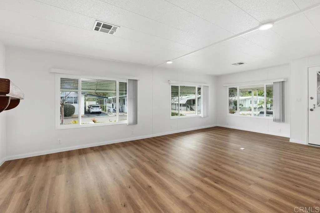 7467 Mission Gorge Road, Unit SPC 10 Santee, CA 92071 - Photo 4 of 44 a view of an empty room with wooden floor and a window