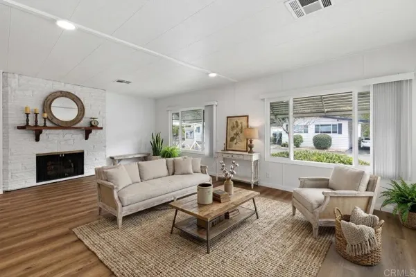 a living room with furniture a fireplace and a large window