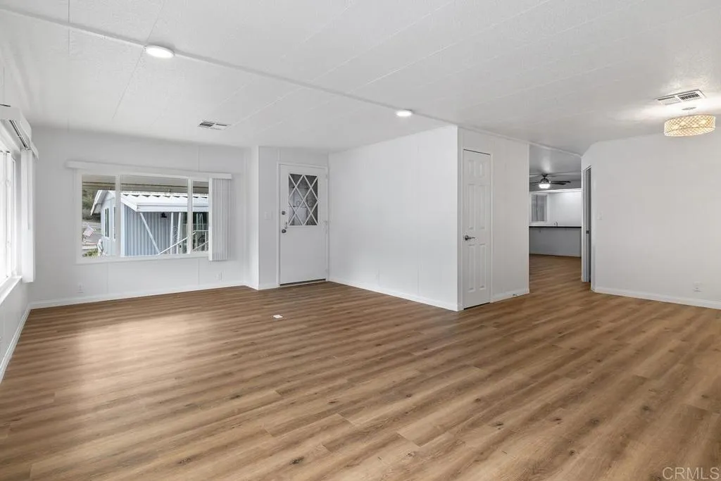 7467 Mission Gorge Road, Unit SPC 10 Santee, CA 92071 - Photo 9 of 44 a view of empty room with wooden floor and kitchen