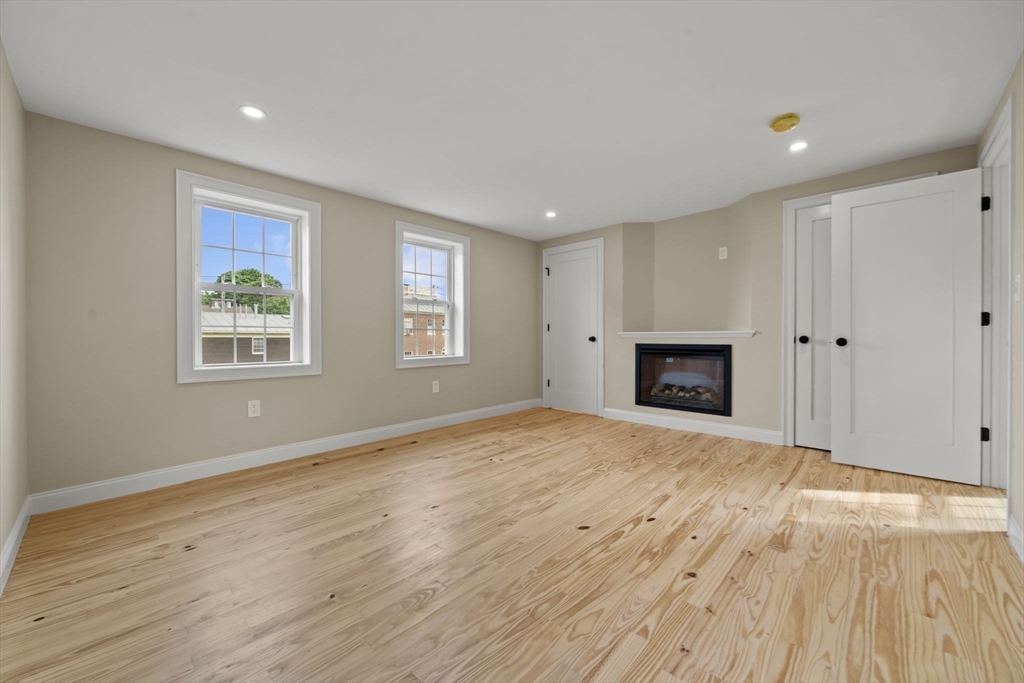 162 High Street, Unit B Danvers, MA 01923 - Photo 21 of 32 a view of empty room with wooden floor and fireplace