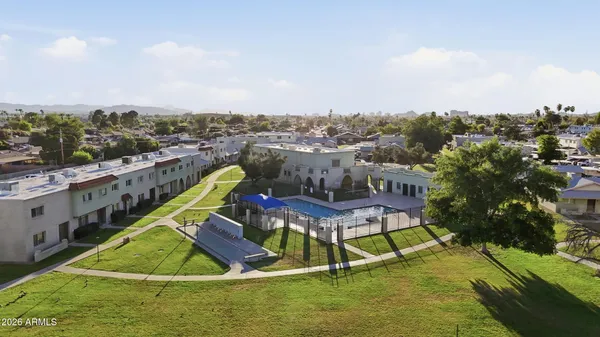 an aerial view of residential houses with outdoor space and trees