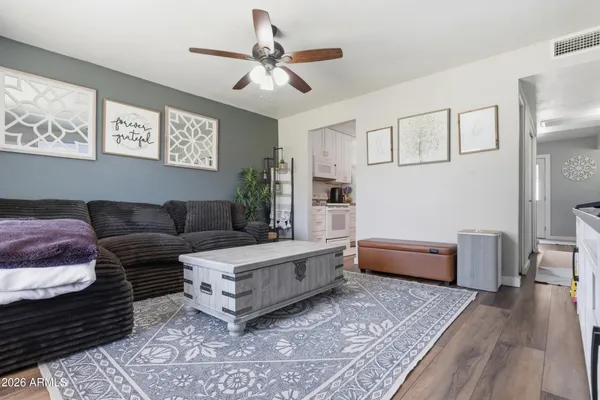 a living room with furniture and a wooden floor
