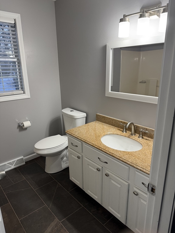 54 Old Fuller Rd Extension Chicopee, MA 01020 - Photo 12 of 25 a bathroom with a granite countertop toilet a sink and mirror