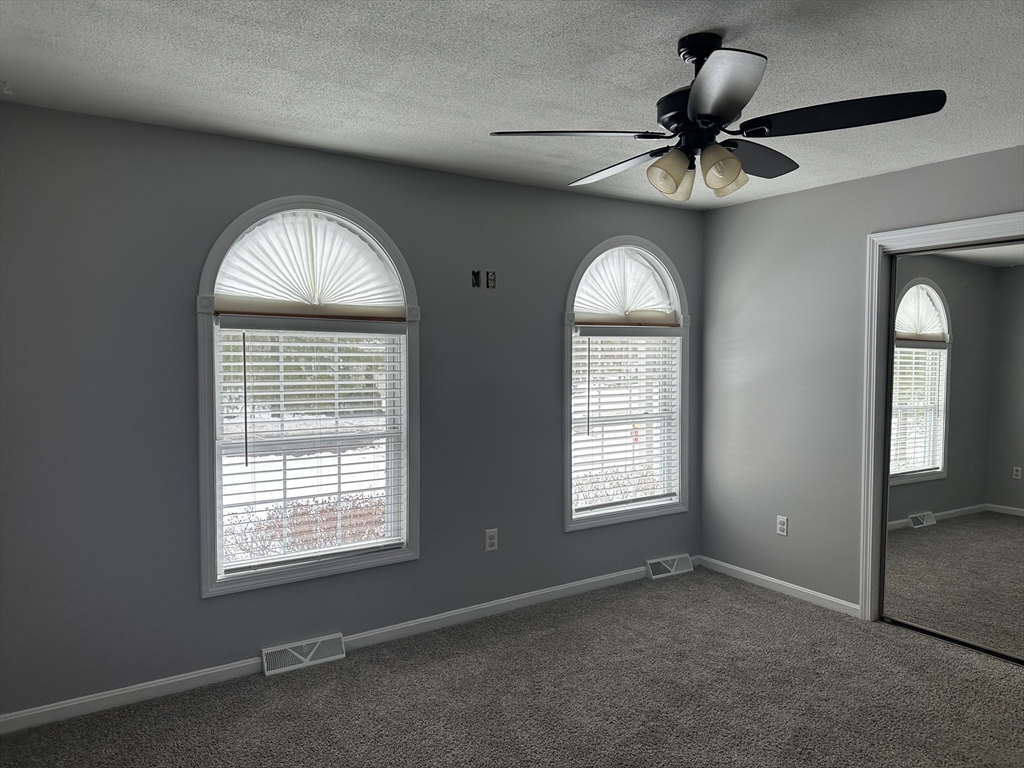 54 Old Fuller Rd Extension Chicopee, MA 01020 - Photo 14 of 25 en empty room with windows and ceiling fan