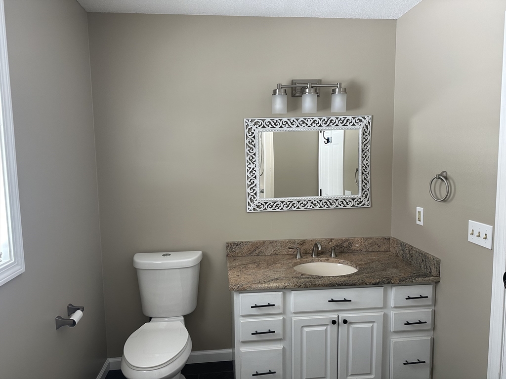 54 Old Fuller Rd Extension Chicopee, MA 01020 - Photo 10 of 25 a bathroom with a granite countertop toilet sink and mirror