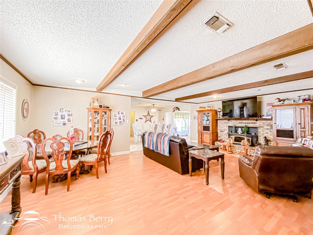 2732 County Road 248 Snyder, TX 79549 - Photo 1 of 1 Living area featuring a textured ceiling, beam ceiling, visible vents, and light wood-type flooring
