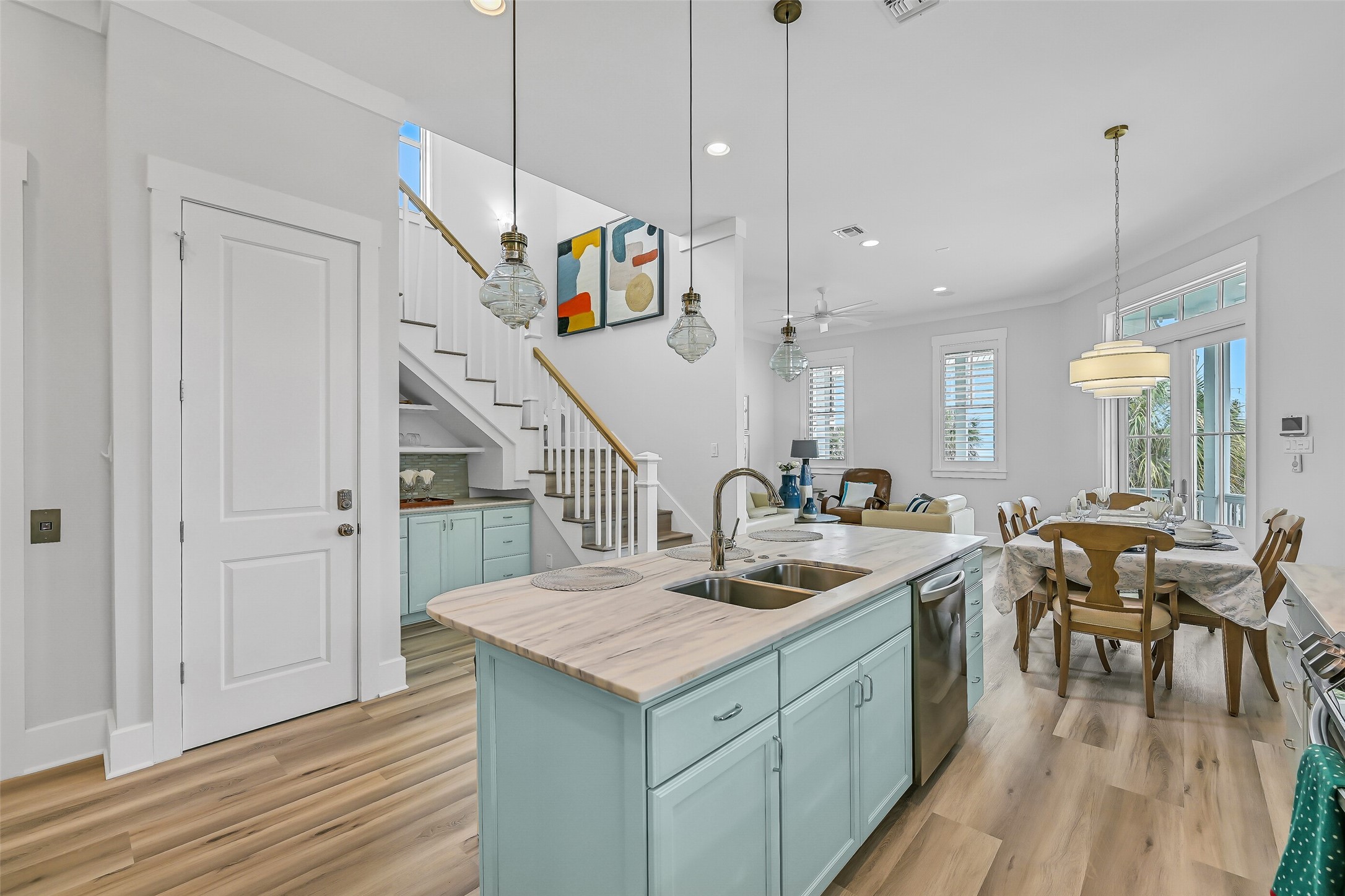 817 Positano Road Galveston, TX 77550 - Photo 18 of 50 Designed for connection and comfort, the spacious island overlooks the dining and living spaces, keeping everyone together while entertaining. New beach-inspired flooring, updated interiors, and abundant natural light create a bright, welcoming atmosphere throughout the heart of the home.