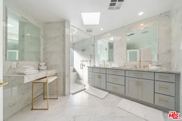 a bathroom with a sink a toilet a mirror and shower