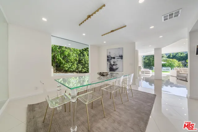 a dining room with furniture and a floor to ceiling window