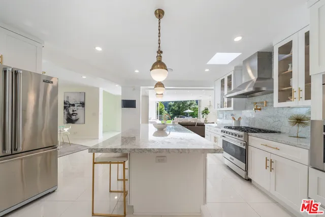 a kitchen with stainless steel appliances granite countertop a sink and refrigerator