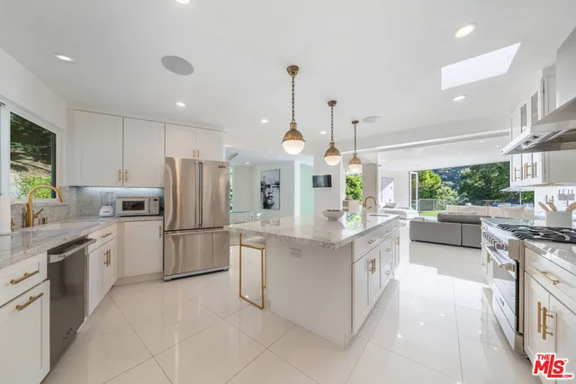 a large kitchen with white cabinets and stainless steel appliances