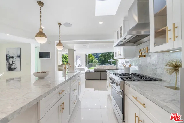 a kitchen with stainless steel appliances granite countertop a stove a sink and a wooden floors