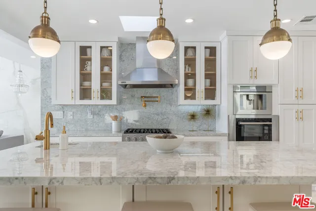 a kitchen with stainless steel appliances granite countertop a stove and cabinets