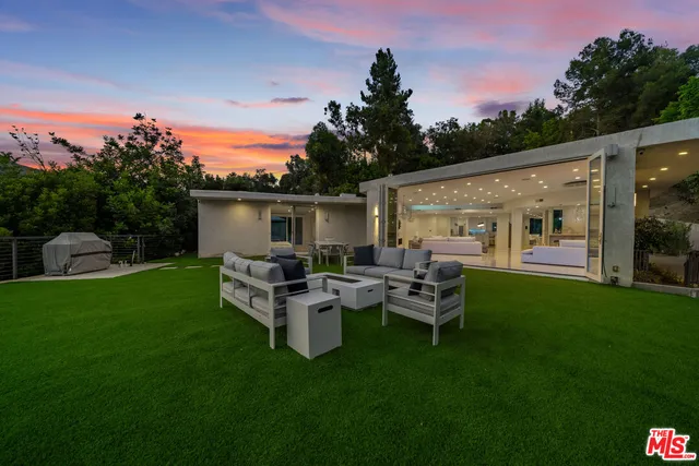 a view of a house with backyard sitting area and garden