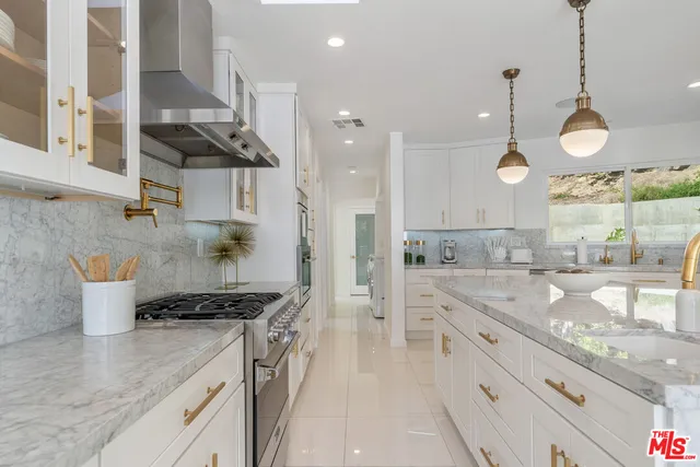 a kitchen with stainless steel appliances granite countertop a sink a stove and a wooden floors