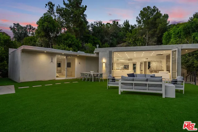 a view of a house with backyard and sitting area