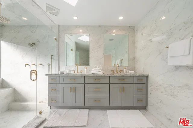 a bathroom with a double vanity sink mirror and shower