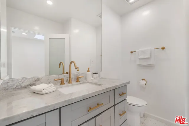 a bathroom with a sink a toilet and a mirror