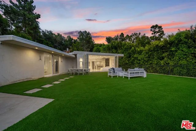 a view of a house with backyard and sitting area