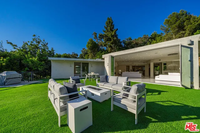 a view of a house with backyard sitting area and garden