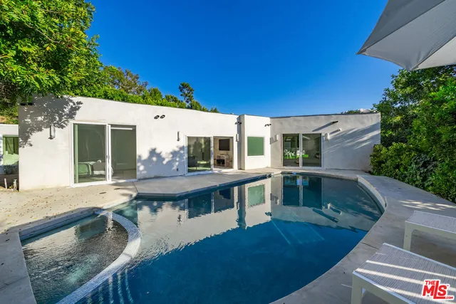 a view of house with swimming pool outdoor seating
