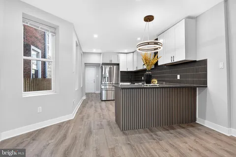 a kitchen with stainless steel appliances granite countertop a sink a stove and a refrigerator