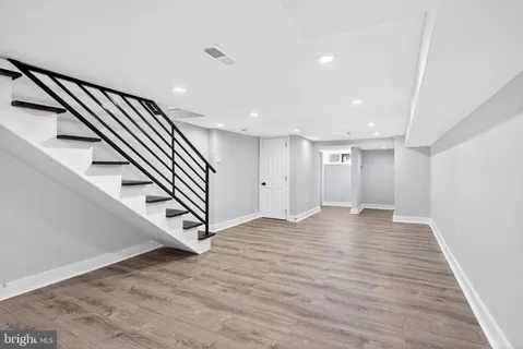 a view of a hallway with wooden floor and closet