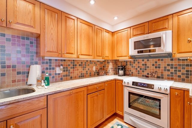 a kitchen with stainless steel appliances wooden cabinets and a stove top oven
