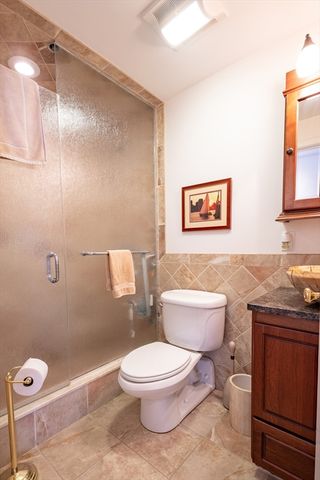 a white toilet sitting next to a bathroom sink and vanity