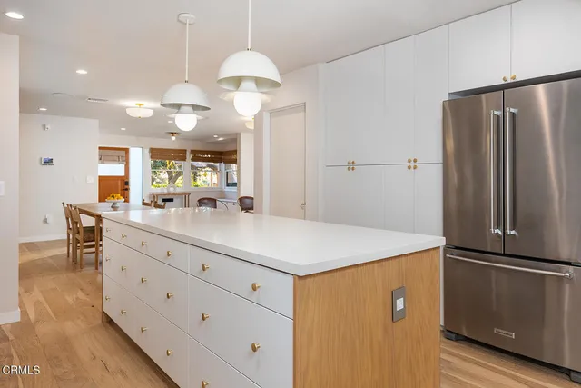 a kitchen with kitchen island white cabinets and stainless steel appliances