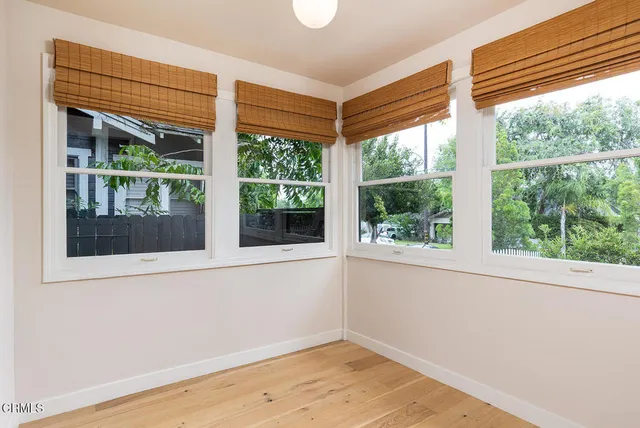 a view of a room that has a window and wooden floor