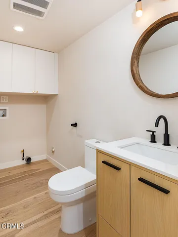 a bathroom with a sink a toilet and a mirror